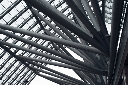 Metal construction. Diagonal iron pipes holding the glass roof, close-up. Cropped image. Urban...