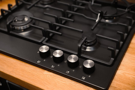 Minimalistic design of a modern gas stove, selective focus on burner control, appearance.