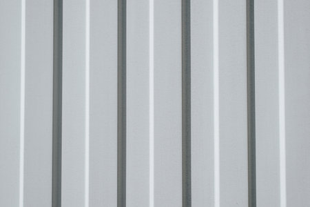 Iron, gray construction profiled sheet with vertical stripes. Closeup of a corrugated building...