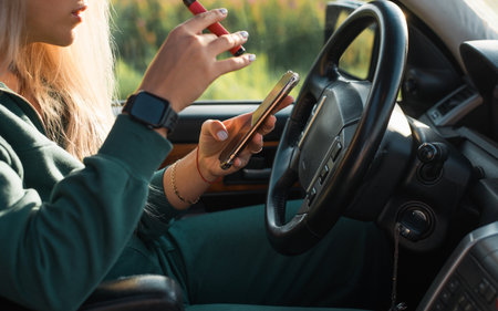 Side view of young caucasian woman sitting behind wheel of car, hipster woman driver smoking an...