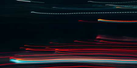 Night city in motion defocus, red lights, horizontal traffic. Abstract blurred bright lights...