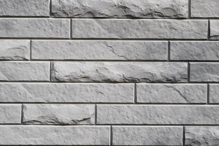 Gray textured brick wall, long and narrow horizontal decorative stone imitation of old, rough and...