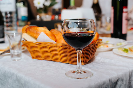 Close-up of glass red wine on table indoors. Alcohol drink in transparent glass, festive event, restaurant concept. Selective focus on foreground.の写真素材