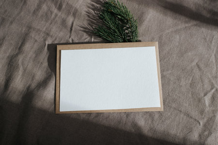 Greeting card mock-up with empty space for New Year invitation or Christmas wishes. White card, pine...
