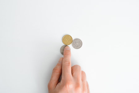 Top view hand counting money on white table, close up finger touching cents. Business concept,...