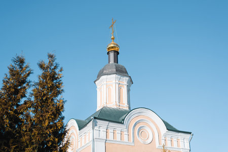 Faith and religion concept. Christian church with golden dome and cross against clear blue sky....