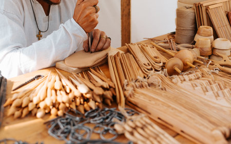 Woodworker working with a knife. Craftsman selling antique wooden handicrafts outdoors. Selective focusの写真素材
