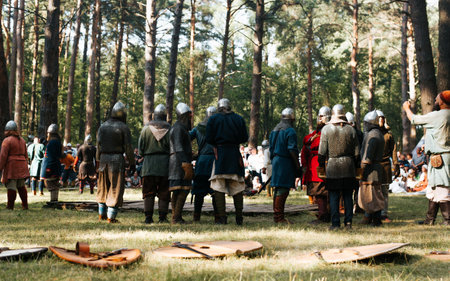 An event of historical reenactment of a medieval battle. War in chain mail and helmets are preparing for a sword fight. Smolensk, Russia 08/13/2022.の写真素材