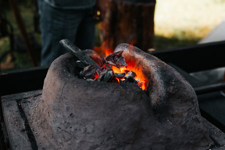 Stone old blacksmith forge. Close-up, selective focus on hot red coals.の写真素材