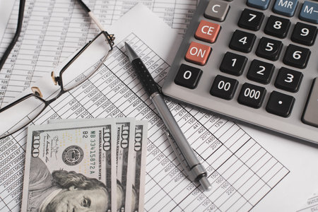 Personal finance, home bookkeeping concept. Money, calculator, invoice documents, pen and eyeglasses close-up.の写真素材