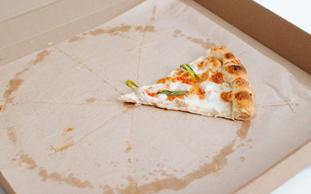 Eaten pizza, one piece on food delivery box.