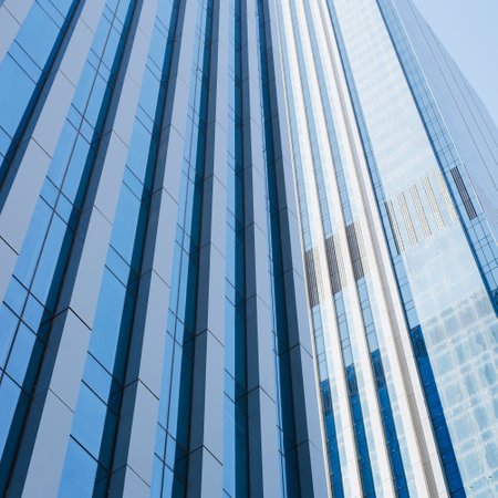 Modern tall skyscraper with blue windows. Business building center exterior and sky, low angle view.