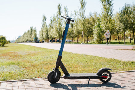 Electric scooter parked in the park on a sunny summer morning.