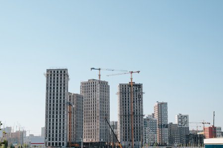 Construction site, cranes building tall residential buildings in the city.の写真素材