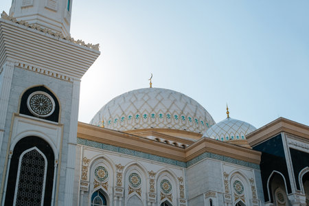Close-up of a white Muslim prayer building mosque with a dome and a creed on a clear sunny day outdoors.の写真素材