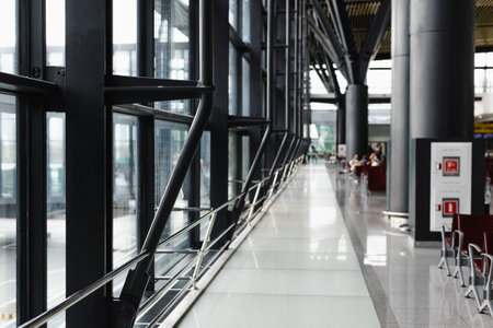 Building with a large hall and windows, selective focus on the construction iron post.