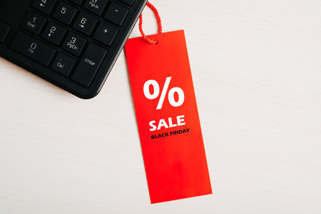 Black friday, computer hardware sale concept. Close-up red tag with Percentage symbol and text Black...