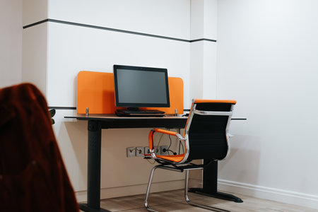 Workplace. Stylish orange workspace no people desk, computer and chair inside the room.の写真素材