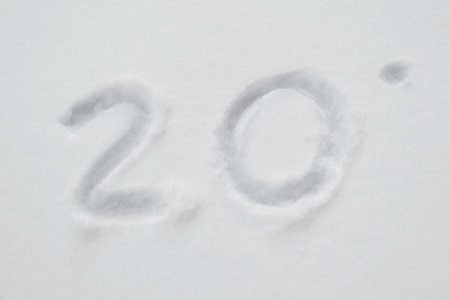 Weather, meteorology, climate concept. Number 20 degrees Fahrenheit in snow on winter day.の写真素材