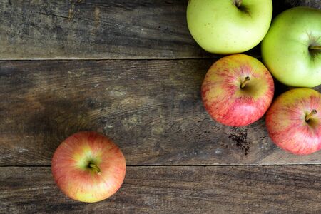 Fresh green and red apples on top of a old wooden tableの写真素材