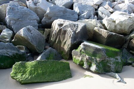 Sea breaker made from natural rock and algae on a beautiful sunny dayの写真素材