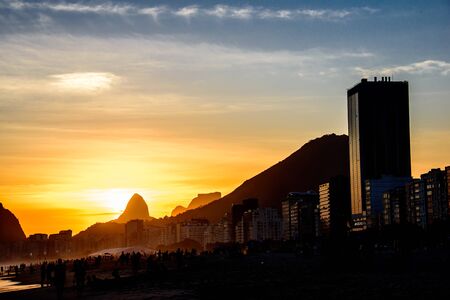 View of Two Brothers Dois Irmaos Mountain and Pedra da Gavea on the background of gold sunset from Copacabana beach, Rio de Janeiro, Brazilの写真素材