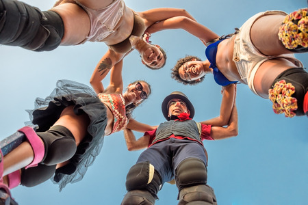 27 November 2016. Three smiling women and one serious clown standing on stilts in the circle at Festival de Fanfarras Ativistas - HONK RiO 2016 in Leme district, Rio de Janeiro, Brazilのeditorial素材