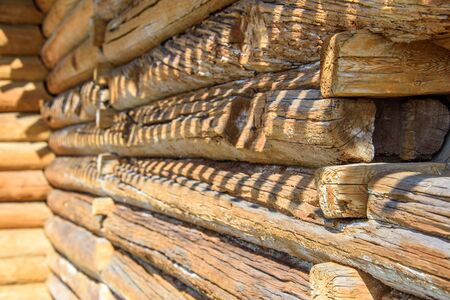 Details of log cabin corner joint with round logs and wall of wooden house at sunny spring day, Moscow, Russiaの写真素材