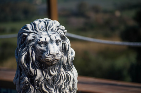 stone lion statue with green defocused backgroundの写真素材