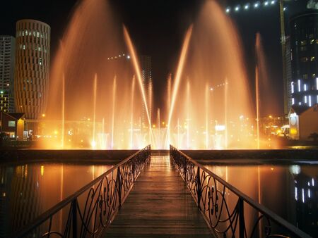 Beautifully illuminated musical fountains on the night boulevard in Batumi, Georgia. Air jets of water are a symbol of abundance and prosperity.の写真素材