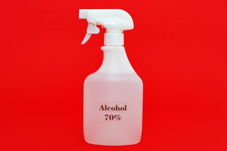 70% alcohol spray for protection against Coronavirus / SARS-CoV-2 / COVID-19 and other contagious diseases. Isolated on red background. Close-up. Horizontal shot.の素材 [FY310144834699]