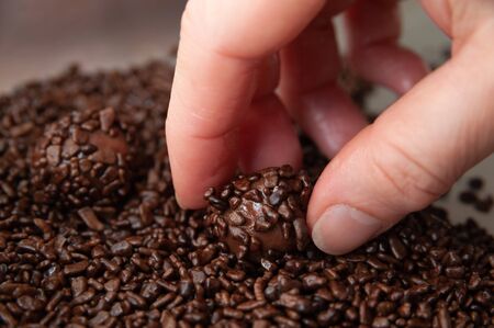 Close-up of woman hand making delicious and traditional â€œBrigadeirosâ€ (Brazilian Fudge...