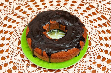 Delicious and healthy traditional Brazilian homemade carrot cake with chocolate sauce. Top view. Background with crochet towel.の写真素材