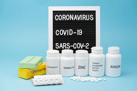 Chloroquine, Hydroxychloroquine Sulfate, Zinc, Ivermectin and Avigan. Some of the drugs currently used in the treatment of COVID-19. Blister pack and scattered pills. Writing board in the background. の写真素材
