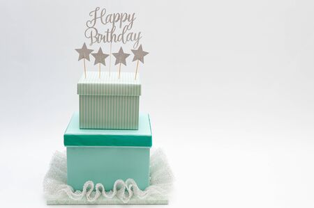 Fake cake - DIY Gift Box Cake. Birthday cake made with boxes. Decorated with colored paper, pleated lace, star shapes and the phrase: Happy Birthday. Isolated on white background. Copy space. の写真素材