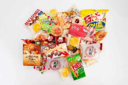 Fuji City, Shizuoka Prefecture, Japan - April 4, 2020: Colorful packaging from various brands of traditional and popular cookies and sweets marketed in Japan. Isolated on white background.のeditorial素材