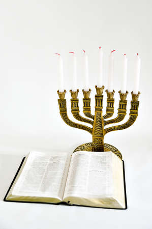 Menorah and open bible with 7 unlit candles isolated on white background. Vertical shot. Copy space.の写真素材