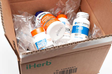 Fuji City, Shizuoka-Ken, Japan - November 7, 2020: Open cardboard box containing supplements and vitamins from the iHerb Online Store.のeditorial素材