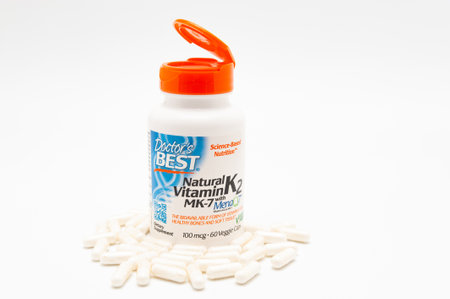 Fuji City, Shizuoka-Ken, Japan - November 7, 2020: Doctor's Best, Natural Vitamin K2 MK-7 with MenaQ7, 100 mcg, 60 Veggie Caps. Scattered pills. Isolated on white background. Copy space.のeditorial素材