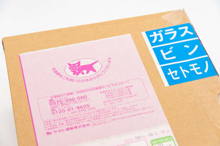 Fuji City, Shizuoka-Ken, Japan - April 29, 2021: Cardboard box with label and logo of the Japanese company YAMATO TRANSPORT known in Japan as Kuroneko (black cat) or Ta-Q-Bin.のeditorial素材