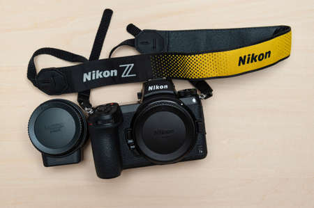Fuji City, Shizuoka Ken, Japan - May 23, 2021: Nikon Z 7II mirrorless digital camera body with neck strap and Mount Adapter FTZ. Isolated on wooden background. Top view.のeditorial素材