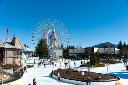 Fuji-Q Highland, Fujiyoshida City, Yamanashi Prefecture, Japan - January 3, 2019: Ice skating area with ferris wheel. Background with beautiful blue sky.のeditorial素材