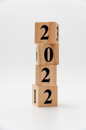 2022 written on wooden blocks in vertical direction isolated on white background.