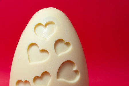 Delicious and original homemade white chocolate Easter egg decorated with heart shapes isolated on...