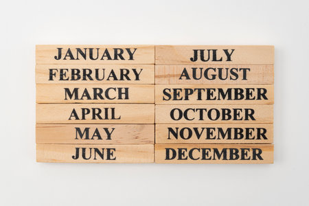 The month of the year written on twelve rectangular pieces of wood. Isolated on white background.の写真素材
