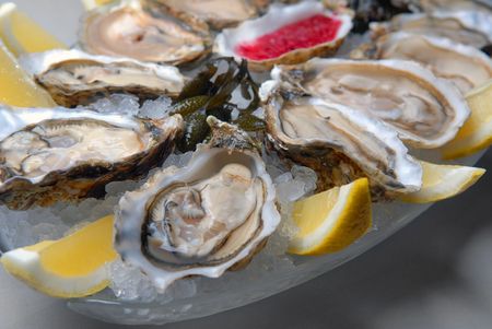 Oysters in ice with a lemon and sauceの写真素材