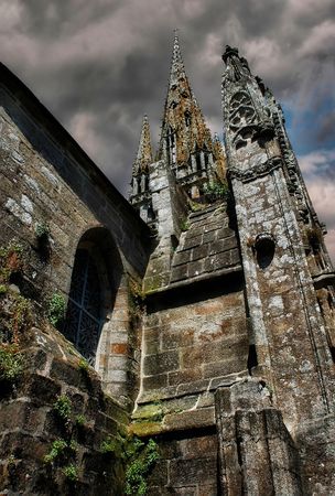Old Catholic church against gloomy cloudsの写真素材