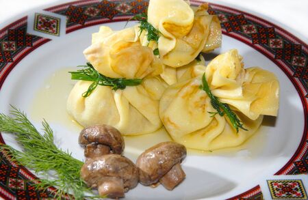 Pancakes with mushrooms on a plate with the Ukrainian ornamentの写真素材