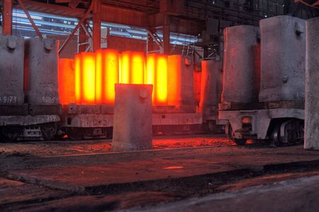 The crane removes forms from the heated steel pigs from a railway platform