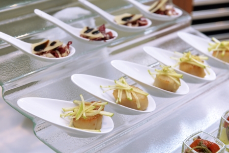 scallops in the spoon on the buffet tableの写真素材